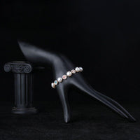 Side angle view of KHAISTA crystal flower stud pearl bracelet