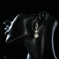 Side angle view of KHAISTA crystal leaf pearl drop earrings