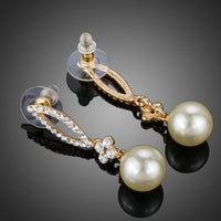 Close up of KHAISTA crystal leaf pearl drop earrings