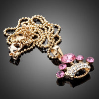 Close up detail of KHAISTA pink crystal crown pendant necklace