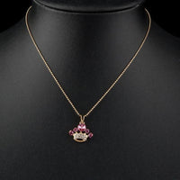 Side angle view of KHAISTA pink crystal crown pendant necklace