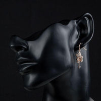 Side angle view of KHAISTA crystal teddy bear earrings