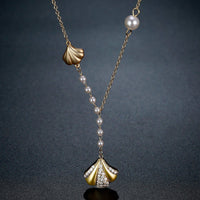 Close up detail of KHAISTA CZ shell long pendant necklace