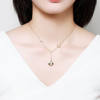 Side angle view of KHAISTA CZ shell long pendant necklace
