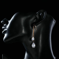Side angle view of KHAISTA crystal swing drop earrings