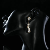 Side angle view of KHAISTA dangling crystal drop earrings