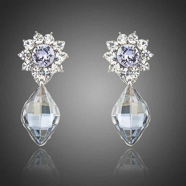 KHAISTA dangling crystal drop earrings on white background