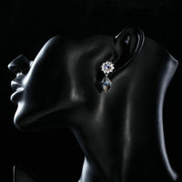 Side angle view of KHAISTA dangling crystal drop earrings