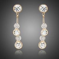 KHAISTA dangling crystal drop earrings on white background