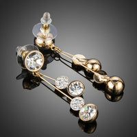 Close up of KHAISTA dangling crystal drop earrings