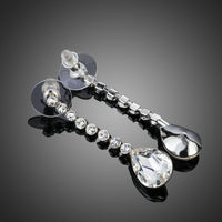 Close up of KHAISTA dangling crystal water drop earrings