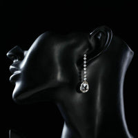 Side angle view of KHAISTA dangling crystal water drop earrings