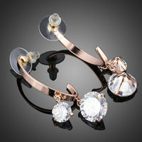 Side angle view of KHAISTA dangling CZ drop earrings