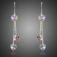 KHAISTA dangling heart crystal drop earrings on white background