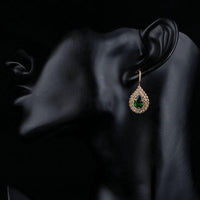 Side angle view of KHAISTA dark green CZ raindrop earrings