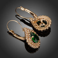 Close up of KHAISTA dark green CZ raindrop earrings