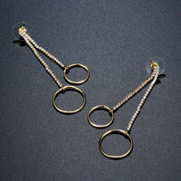 Close up of KHAISTA double circle crystal drop earrings