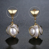 Close up of KHAISTA elegant pearl drop earrings
