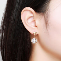Side angle view of KHAISTA elegant pearl drop earrings