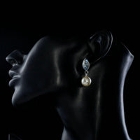 Side angle view of KHAISTA fancy pearl drop earrings