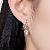 Close up of KHAISTA clear CZ fashion drop earrings