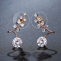 Side angle view of KHAISTA clear CZ fashion drop earrings