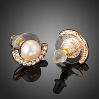 Side angle view of KHAISTA pearl half ellipse rhinestone stud earrings