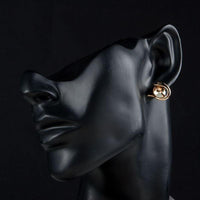 Side angle view of KHAISTA crystal fish porpoising stud earrings