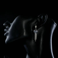 Side angle view of KHAISTA flower crystal tassel drop earrings