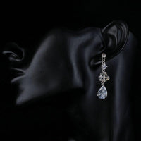 Side angle view of KHAISTA flower design CZ drop earrings