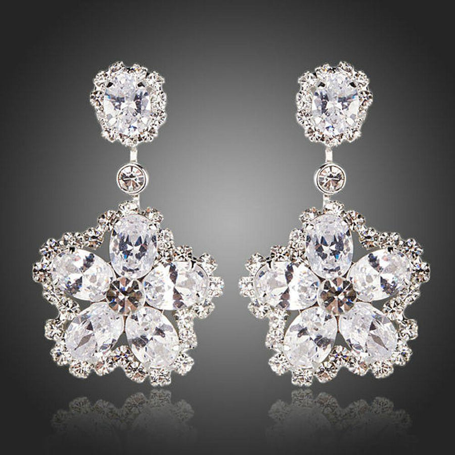 KHAISTA flower star CZ drop earrings on white background