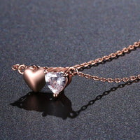 Side angle view of KHAISTA forever love double heart pendant necklace