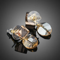 Close up of KHAISTA geometric crystal drop earrings