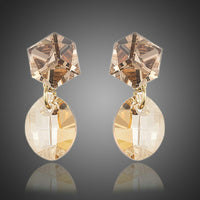 KHAISTA geometric crystal drop earrings on white background