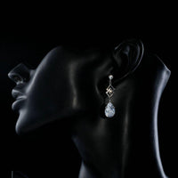 Side angle view of KHAISTA geometric CZ earrings