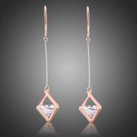 KHAISTA geometric hollow dangle earrings on white background