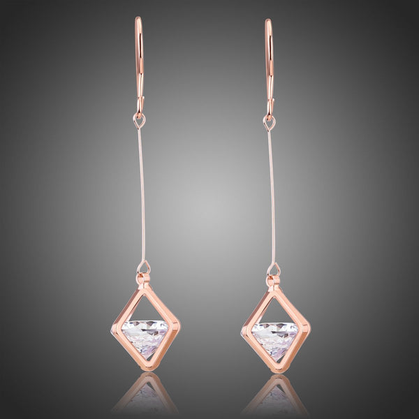 KHAISTA geometric hollow dangle earrings on white background