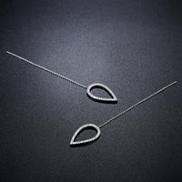 Close up of KHAISTA geometric long drop earrings