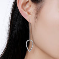 Side angle view of KHAISTA geometric long drop earrings