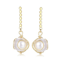 Close up of KHAISTA geometric pearl drop earrings