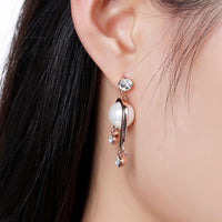 Close up of KHAISTA geometric pearl rhinestone dangle earrings