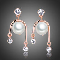 KHAISTA geometric pearl rhinestone dangle earrings on white background