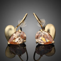 KHAISTA gold plated broken heart drop earrings on white background