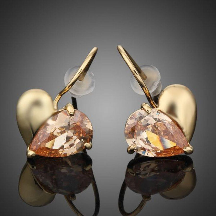 KHAISTA gold plated broken heart drop earrings on white background