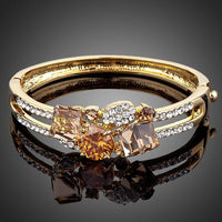 KHAISTA gold plated caramel crystal bangle on white background