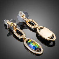 Close up of KHAISTA gold plated chain circle drop earrings