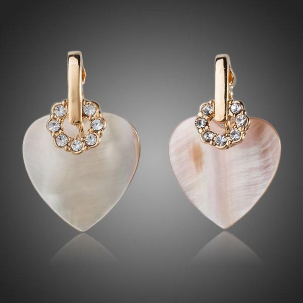 KHAISTA gold plated light peach crystal heart earrings on white background