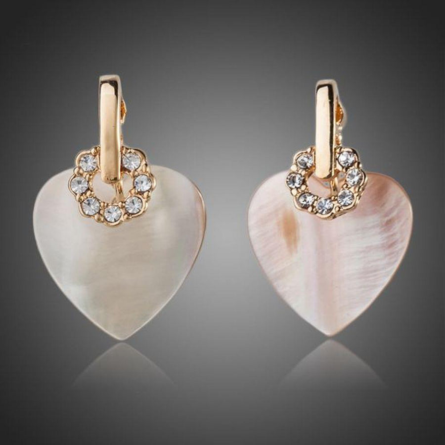 KHAISTA gold plated light peach crystal heart earrings on white background