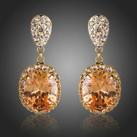 KHAISTA gold plated caramel CZ drop earrings on white background
