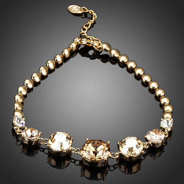 KHAISTA gold plated CZ charm bracelet on white background